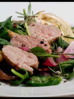 A plate with Pork Tenderloin with Fennel, onions and greens.