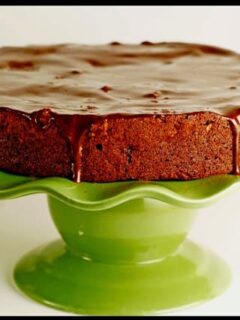 A Chocolate Armagnac Cake sits on a green cake stand.