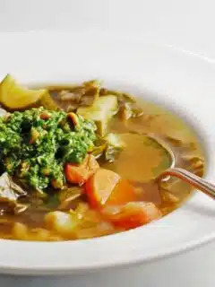 A bowl of soup with vegetables and ramp pesto.