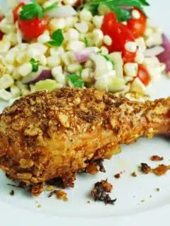 A plate with grilled chicken and white corn.