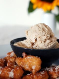 A bowl of fried doughnuts with cinnamon gelato and sunflowers.