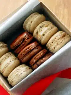 Eggnog Macarons in a box with a red ribbon.
