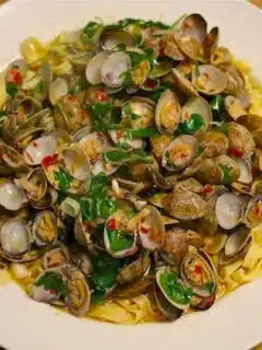 A plate of pasta with spicy clams and herbs.