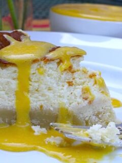 A slice of goat cheese cheesecake with passion fruit curd on a plate.