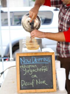 At the Berkeley Farmer's Market, a man carefully pours coffee into a cup.
