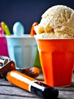 Delicious brown butter ice cream in colorful cups on a wooden table.