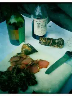 A knife on a cutting board next to a bottle of wine in Gascony, France.