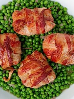 Bacon wrapped peas on a white plate are a perfect side dish to serve with French Pork Parcels.