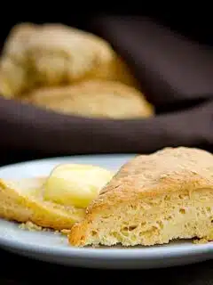 A plate of savory Parmesan scones with butter on it.