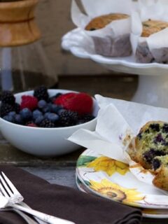Blueberry muffins on a wooden table with a cup of coffee, the scent of lemon and thyme filling the air.
