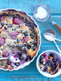 A blueberry tart sits on a rustic wooden table.