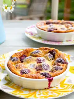 Two bowls of gluten-free cherry clafoutis on a table.