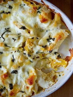 A white dish with cheesy pasta shells in it.