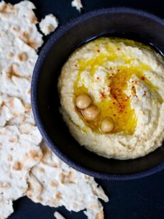 A bowl of Roasted Garlic Hummus served with pita bread.