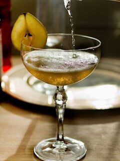 A Eau de Vie Poire Cocktail is elegantly poured into a martini glass.