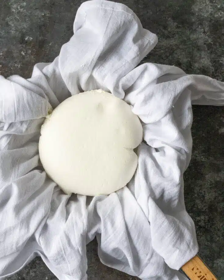 A white cloth with a ball of homemade labneh cheese on it.