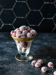Sparkly sugared cranberries in a glass bowl.