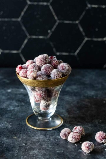 Sparkly sugared cranberries in a glass bowl.