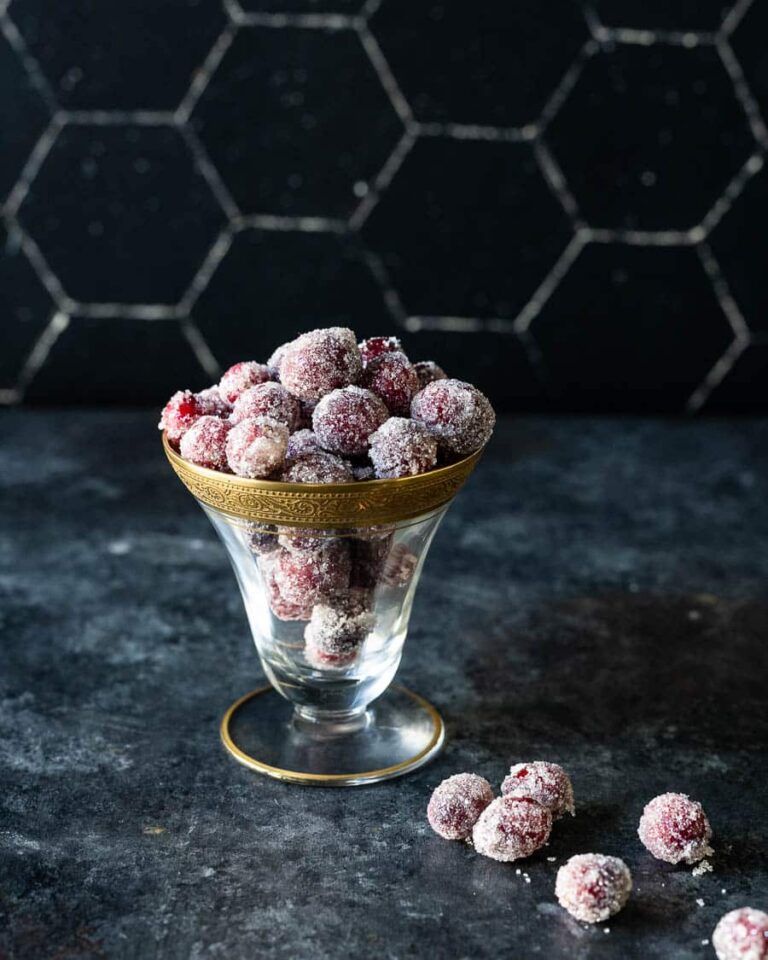 Sparkly sugared cranberries in a glass bowl.